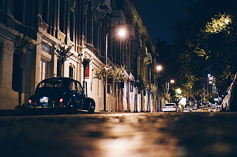 Vintage black car parked on a quiet city street at night