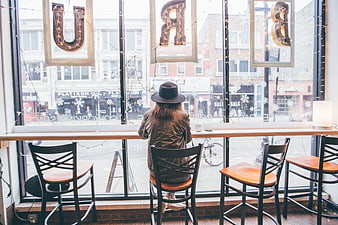 Woman in Hat Sitting at Coffee Shop Window