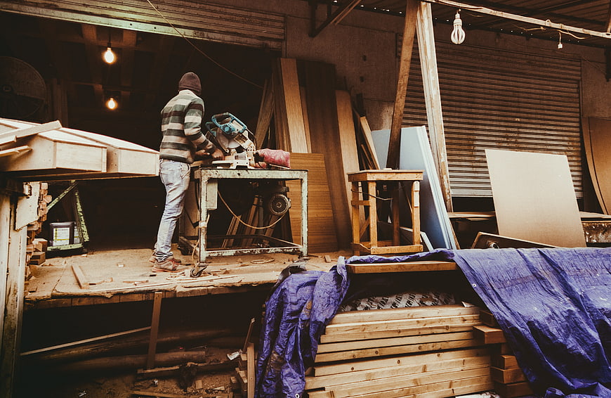 Carpenter working with circular saw in rustic workshop