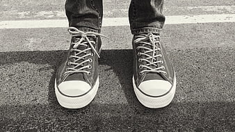 Black and white sneakers on asphalt road