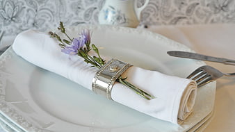 Elegant white table setting with floral napkin ring