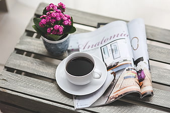 Coffee cup and magazine on rustic wooden table