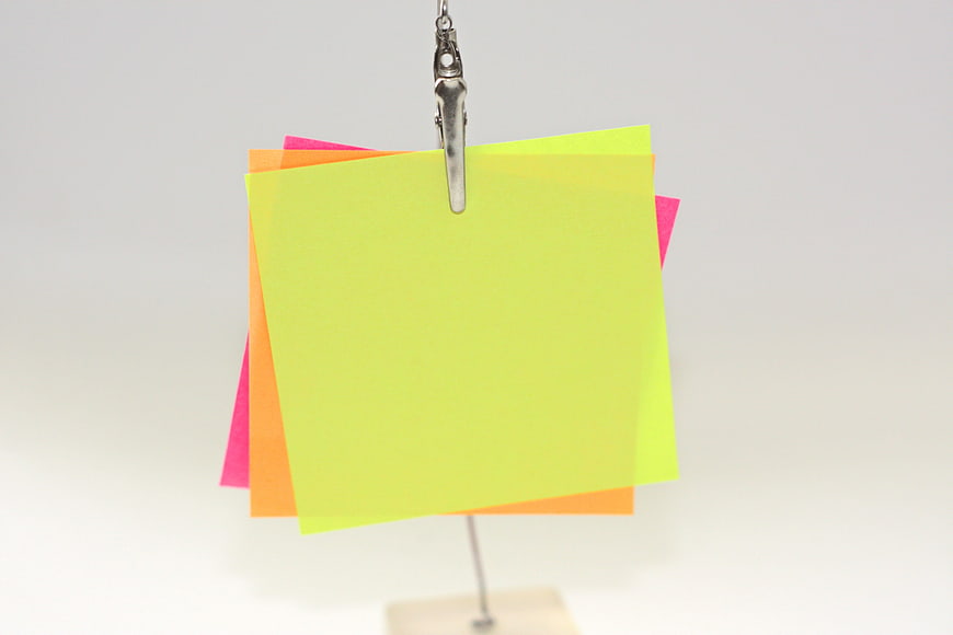 Colorful sticky notes hanging on a metal clip
