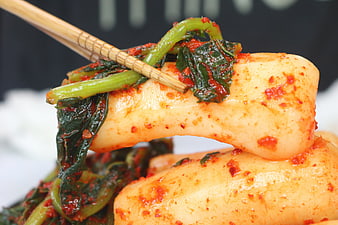 Close-up of spicy Korean radish kimchi with chopsticks