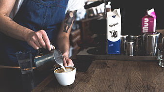 Barista Pouring Latte Art in Coffee Shop