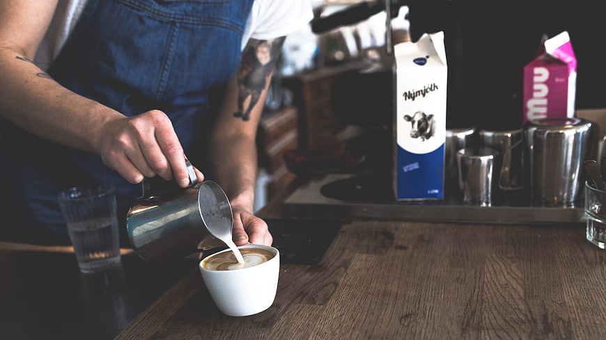 Barista Pouring Latte Art in Coffee Shop