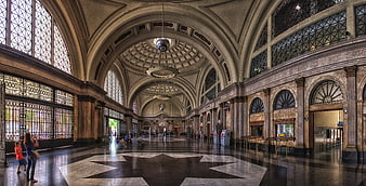 Grand arched interior of a historic train station with marble floors