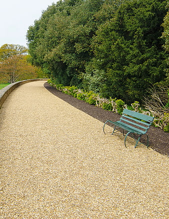 Empty Green Bench on Curved Gravel Path in Park