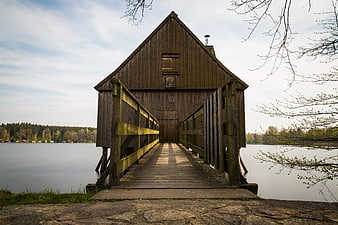 Rustic wooden boathouse on a calm lake with leading lines