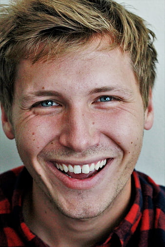 Close-up portrait of a smiling young man with blue eyes