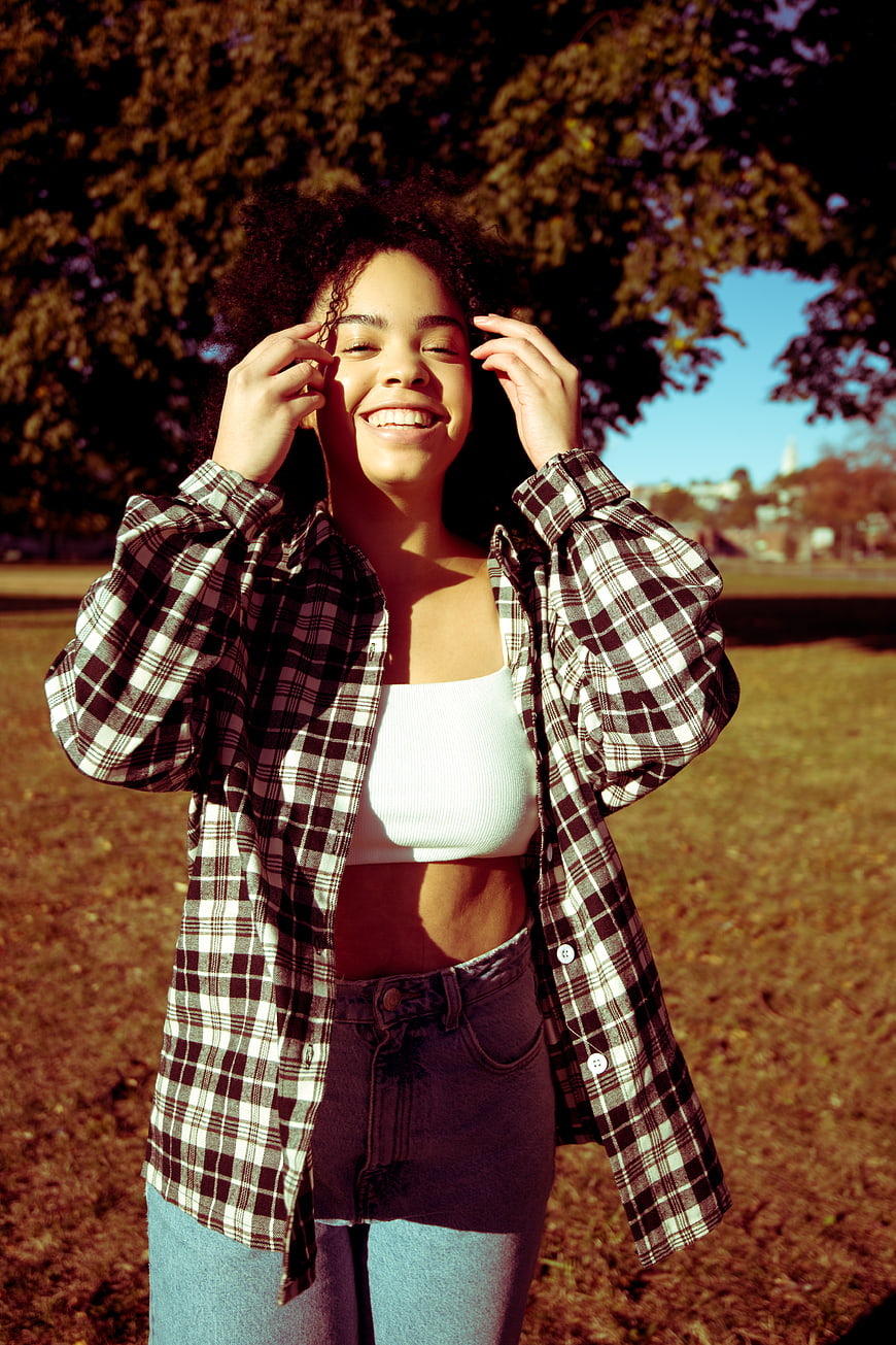 Happy Woman in Plaid Shirt Smiling in Park