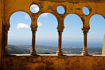 View Through Yellow Arched Balcony to Coastal Landscape