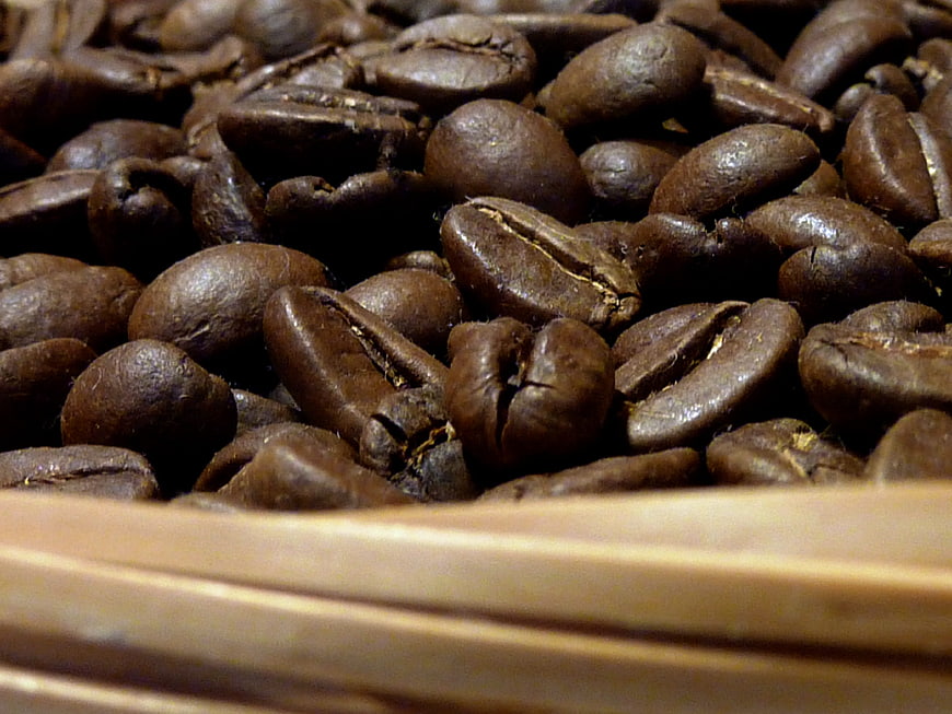 Close-up of roasted coffee beans in a wooden bowl
