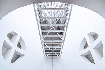 Symmetrical white architectural interior with geometric ceiling details