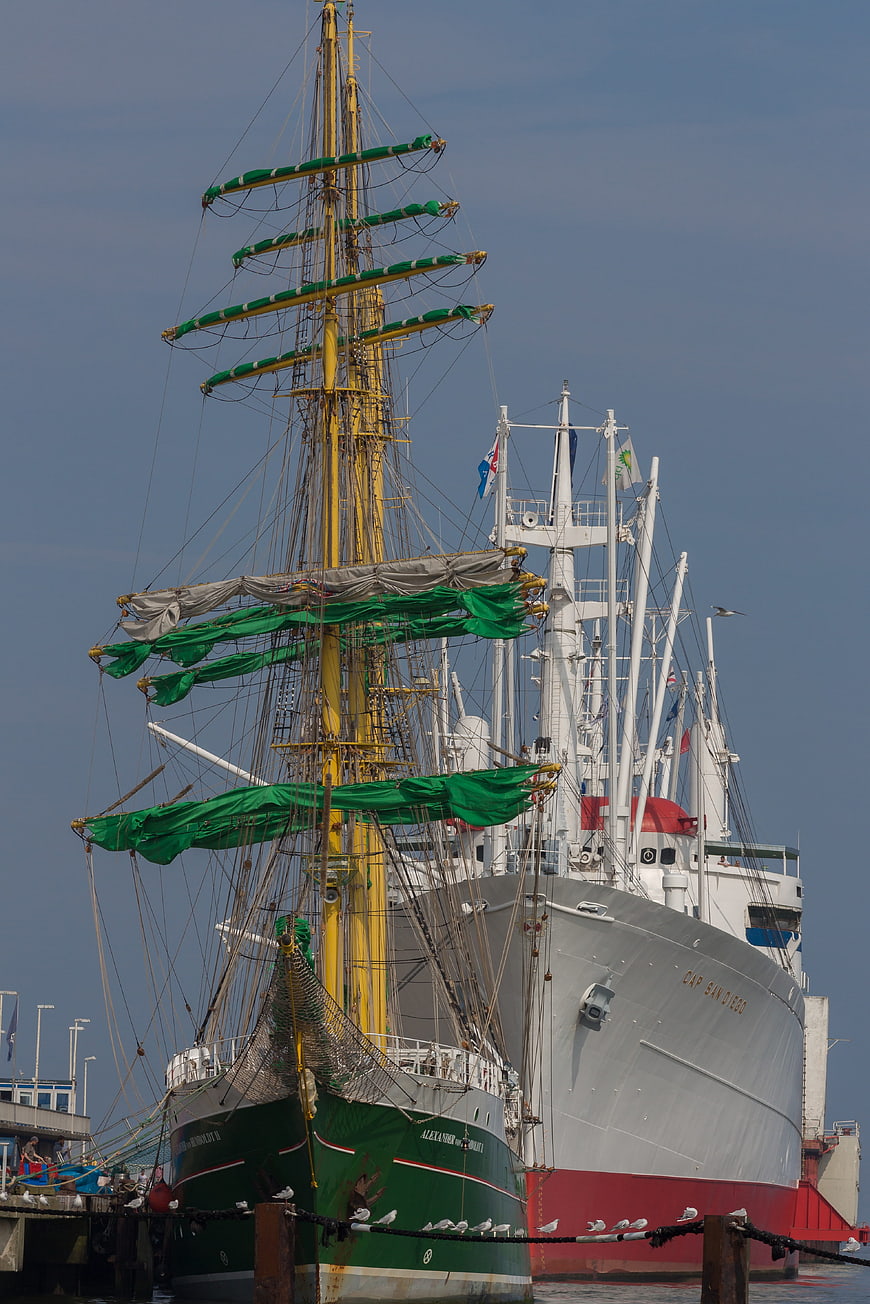 Historic sailing ships docked at a harbor