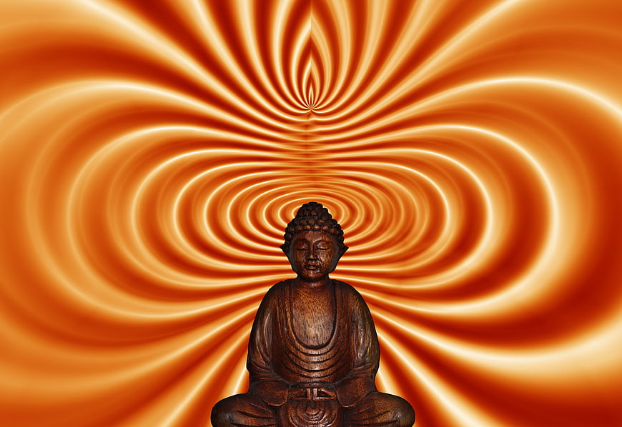 Wooden Buddha Statue Against Abstract Orange Swirl Background