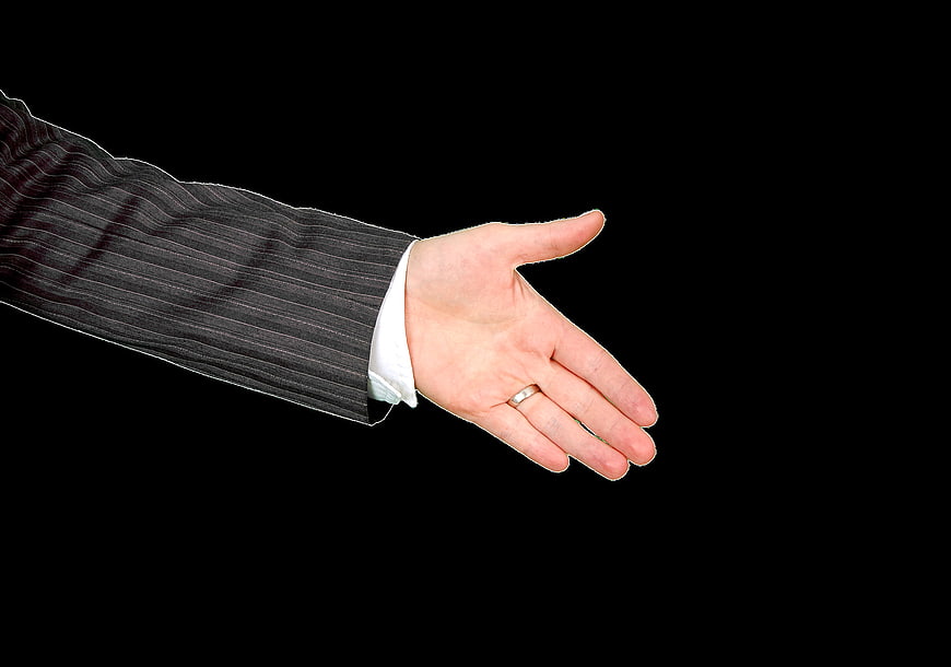 Businessman's open hand gesture on black background