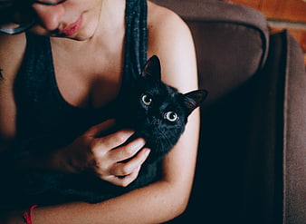 Woman Cuddling Black Cat on Couch