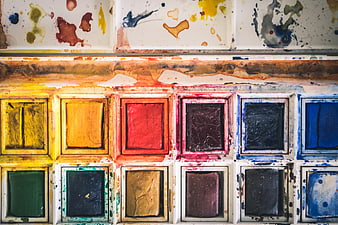 Close-up of used watercolor paint palette with vibrant colors