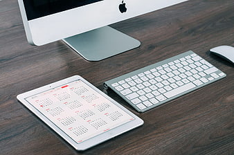 Modern Workspace with Tablet Calendar and Apple Keyboard