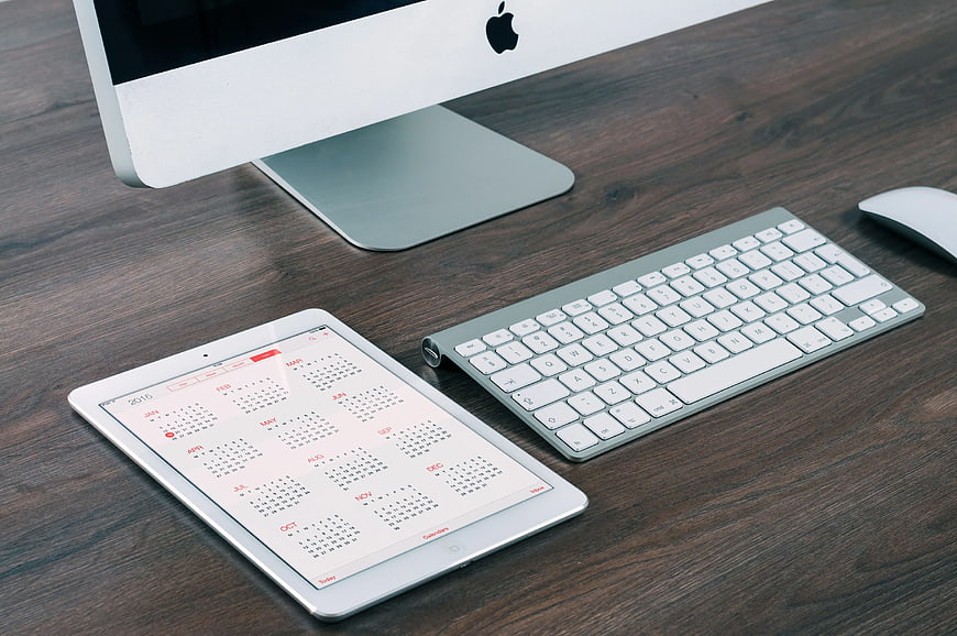 Modern Workspace with Tablet Calendar and Apple Keyboard