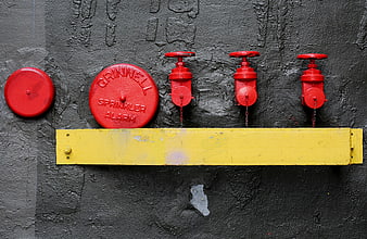 Red Fire Sprinkler Alarm and Valves on Gray Wall