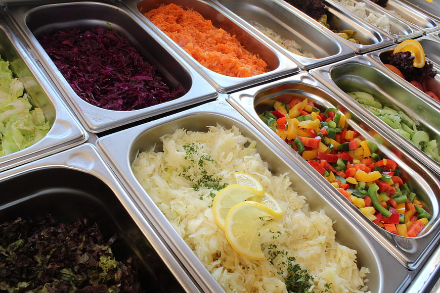 Fresh salad bar buffet with colorful vegetables in metal trays