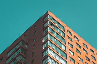 Modern Orange Brick Building Against Teal Sky