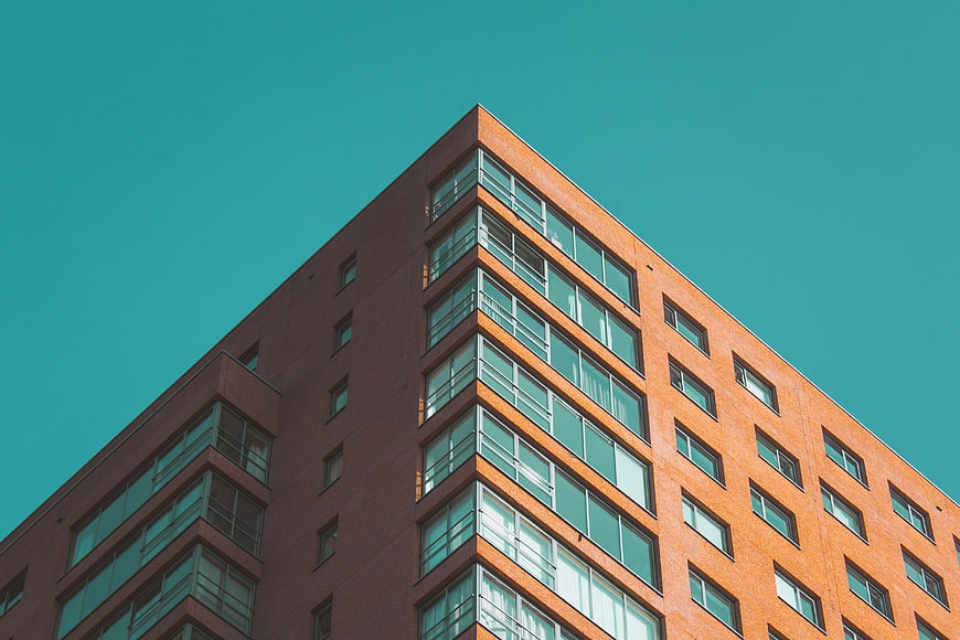 Modern Orange Brick Building Against Teal Sky