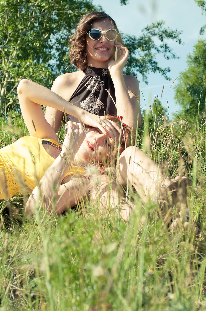 Two women relaxing in tall grass on a sunny summer day