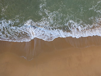 Aerial View of Ocean Waves Crashing on Sandy Beach
