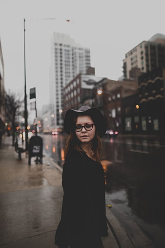 Woman in Hat and Glasses on Rainy City Street
