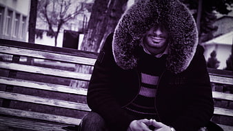 Man in Fur Hat Sitting on Park Bench in Winter