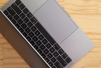 Close-up of silver laptop keyboard on wooden desk