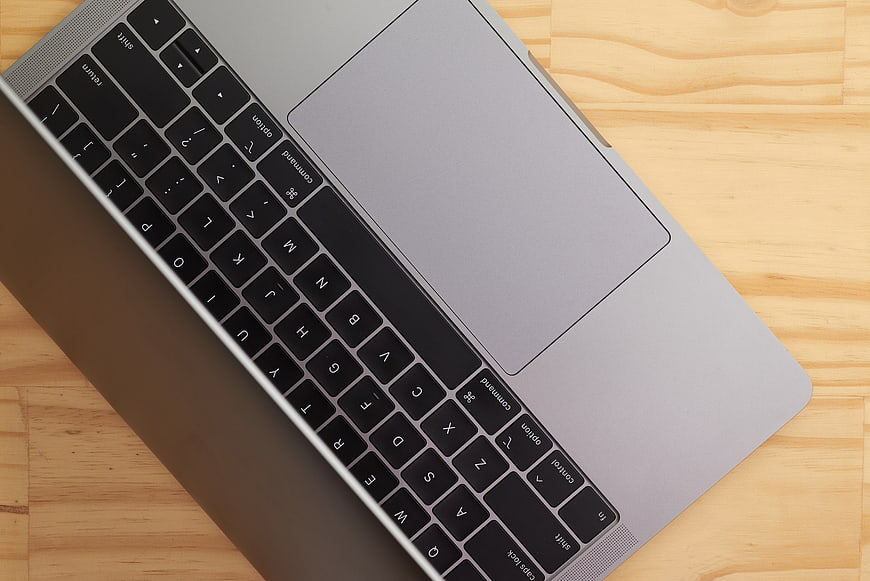 Close-up of silver laptop keyboard on wooden desk