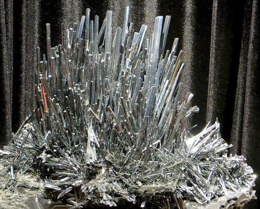 Close-up of silvery metallic mineral crystals on dark background