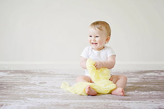 Happy Baby Sitting on Floor with Yellow Fabric