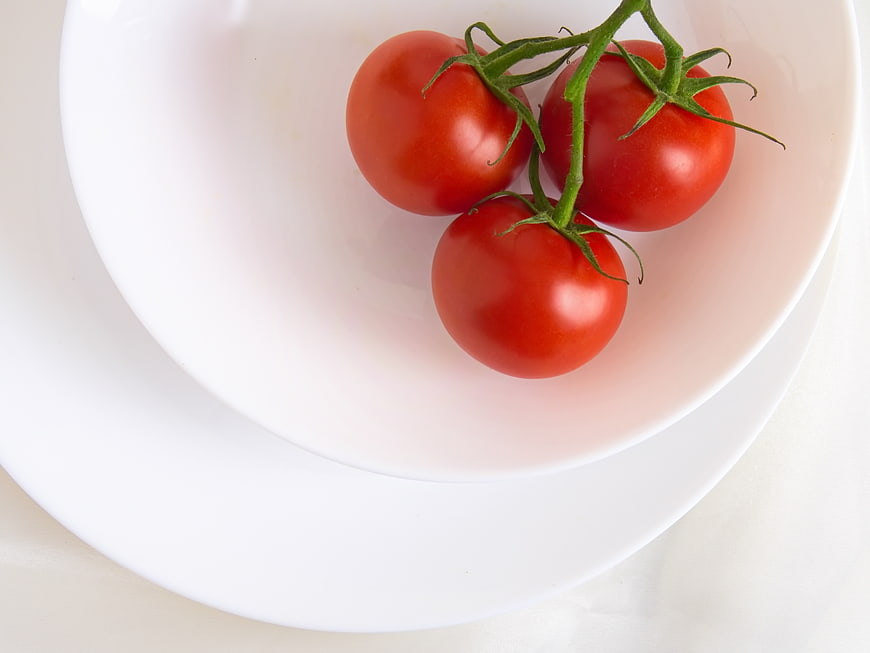 Fresh Red Tomatoes on the Vine in a White Bowl