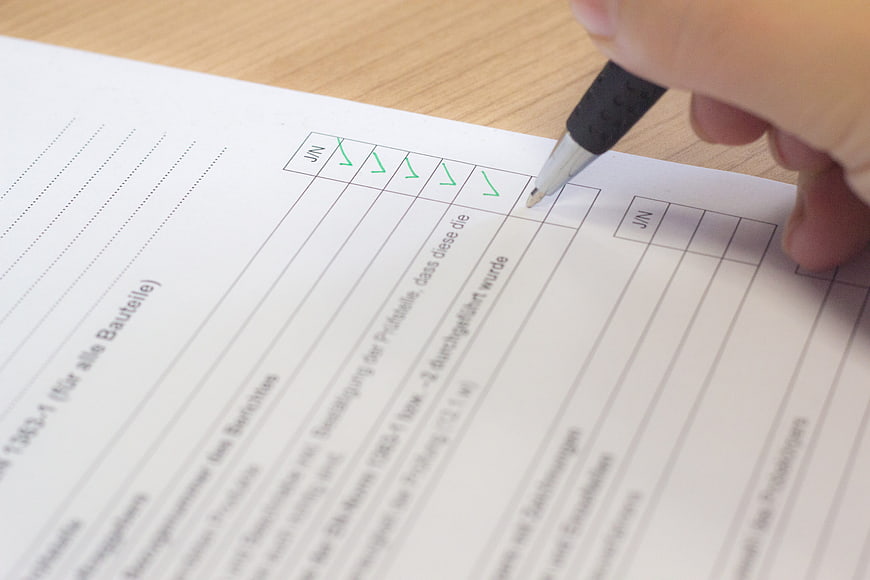 Hand Checking Off Items on a German Checklist Form