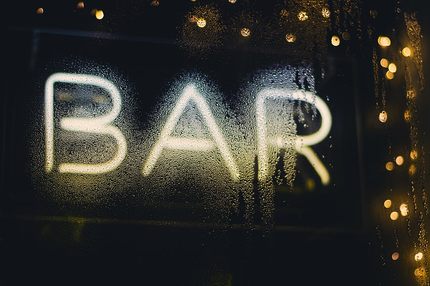 Neon Bar Sign Through Rainy Window at Night