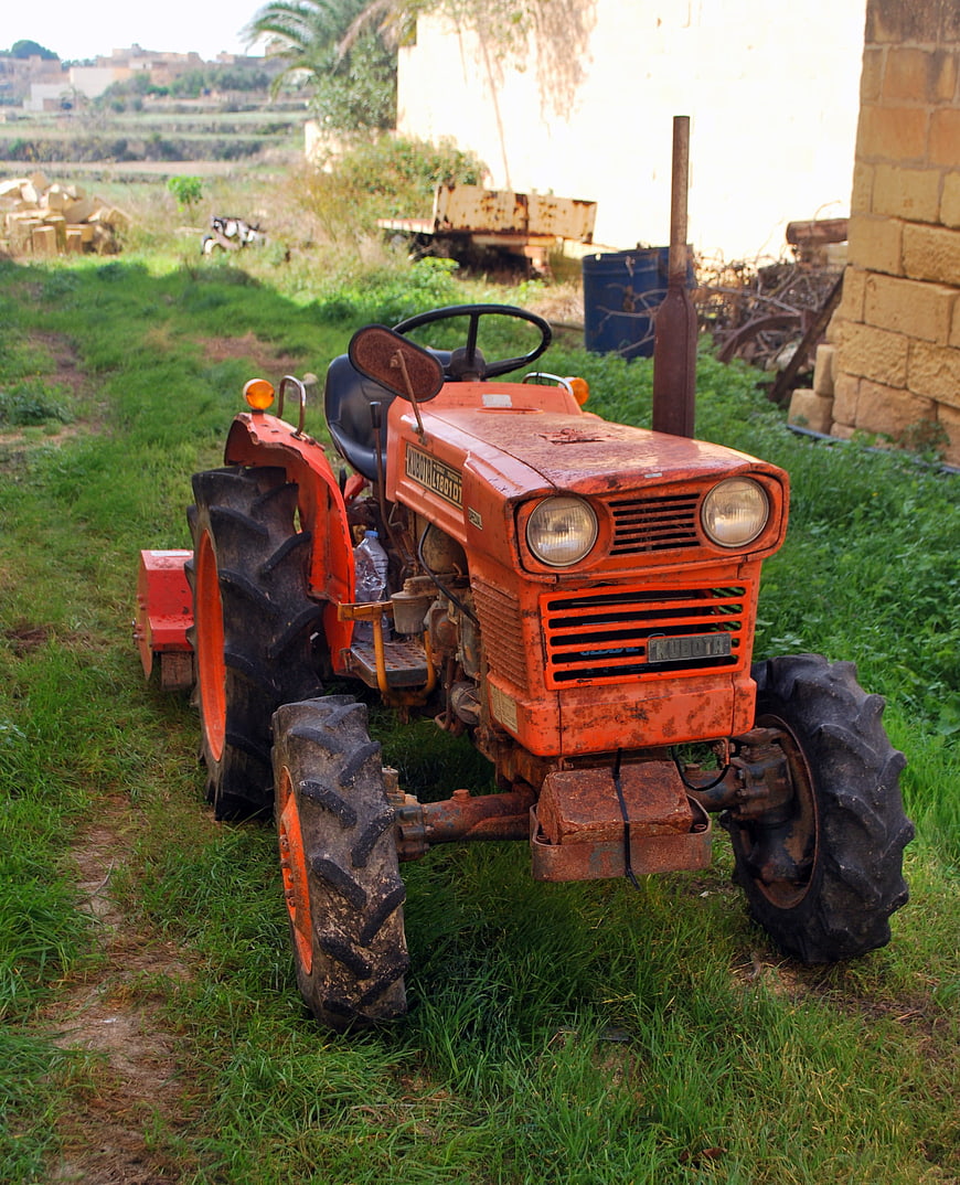 Vintage Orange Tractor Parked on Grassy Farm Field