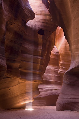 Sunbeam illuminating sandstone walls in slot canyon