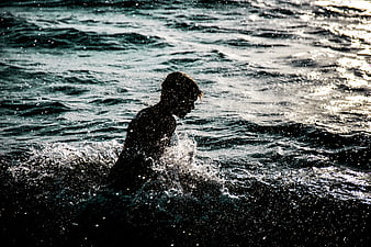 Silhouette of Person Splashing in Ocean Waves