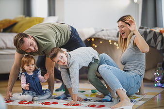 Happy family playing Twister game on living room floor