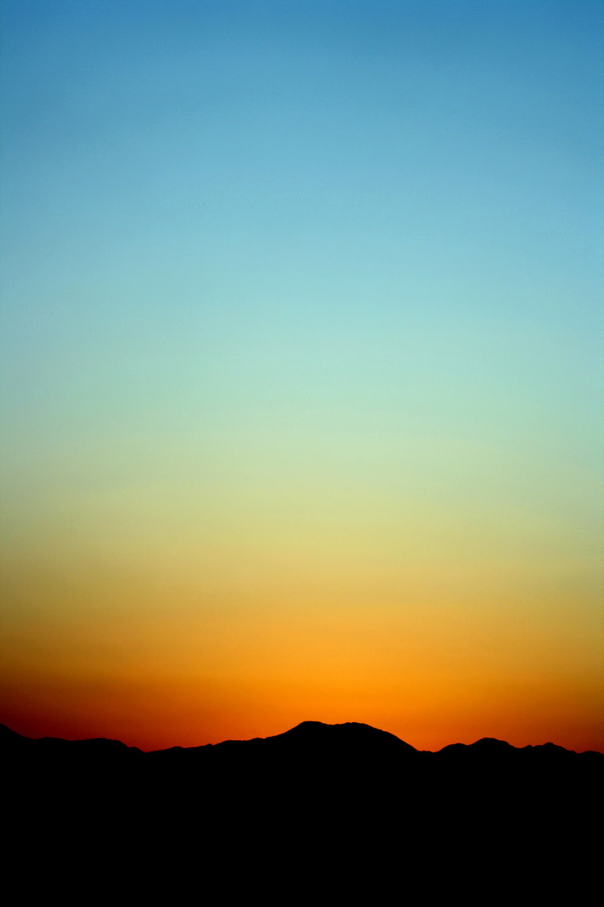 Silhouette of Mountains Against a Colorful Sunset Sky Gradient