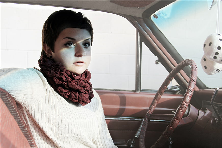 Woman with short hair sitting in vintage car interior