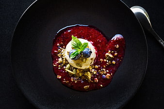 Overhead view of gourmet dessert with berry sauce and granola
