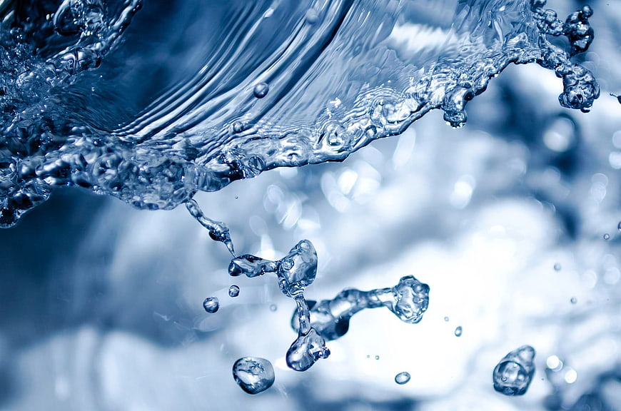 Close-up of splashing blue water droplets and liquid flow