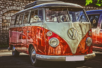 Classic Red and Silver VW Camper Van Parked Against Stone Wall