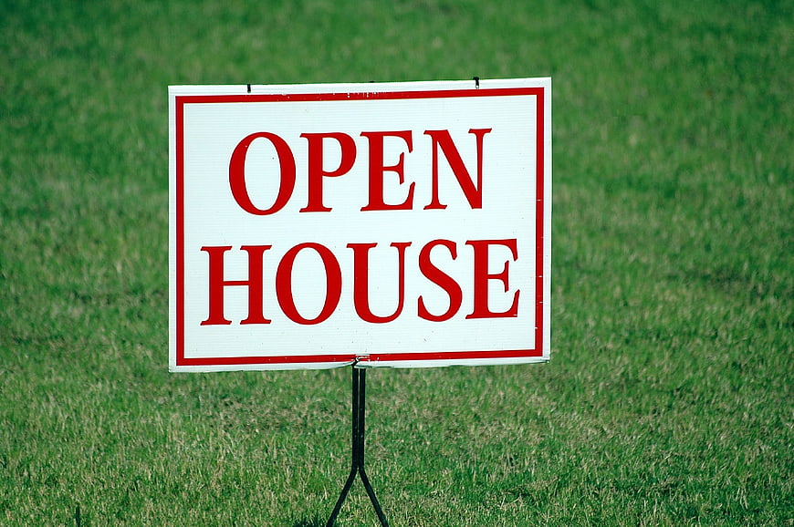 Red and White Open House Sign on Green Lawn